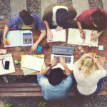 alma-mater-students-at-a-picnic-table-working-on-academic-tutoring